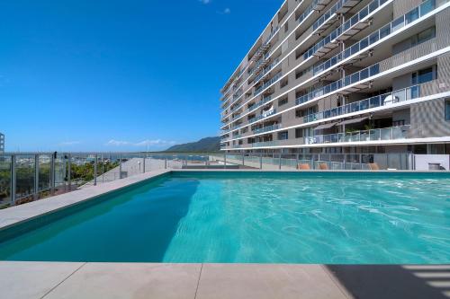 a swimming pool in front of a large apartment building at Belle Escapes 24 Harbour Lights Water View Apartment in Cairns