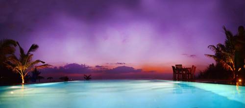 una gran piscina con puesta de sol en el fondo en Palagama Beach Resort, en Kalpitiya