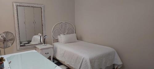 ブロウベルフストランドにあるShalom beach houseの白いベッドルーム(ベッド1台、鏡付)