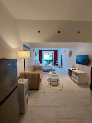 een grote woonkamer met een bank en een tv bij Slique Apartment in Ukunda