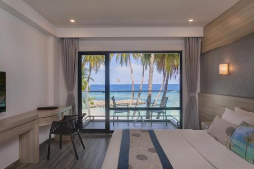 a bedroom with a bed and a view of the ocean at Kaani Grand Seaview in Maafushi