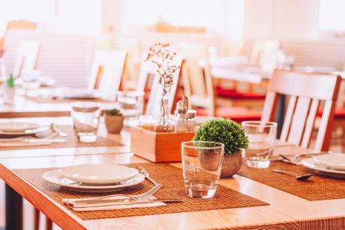 a wooden table with plates and glasses on it at Hotel Zum Ochsen in Oberstenfeld