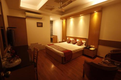 a bedroom with a bed and a television in it at Hotel Clark Height @New Delhi in New Delhi