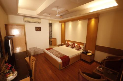 um quarto com uma cama num quarto com pisos em madeira em Hotel Clark Height @New Delhi em Nova Deli