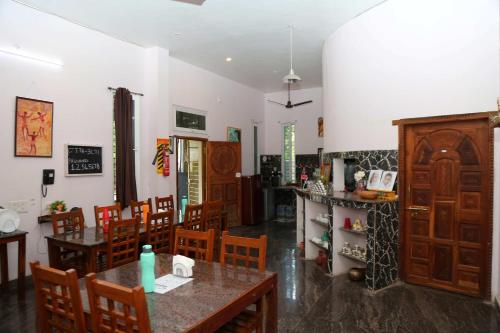 a dining room with wooden tables and chairs at Art Le Cafe in Auroville
