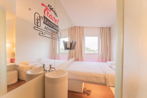 a hotel room with a bed and a sink at J Icon Hip Hotel in Balikpapan