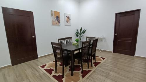 a dining room with a black table and chairs at Tokiku Homestay Paka unit B in Paka