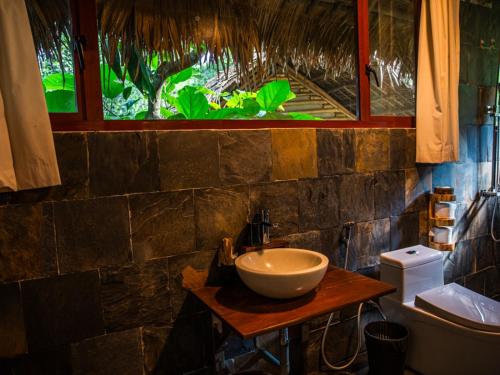 a bathroom with a bowl sink and a window at Pu Luong Jungle Lodge in Pu Luong