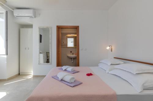 a white bedroom with a bed with towels and a sink at guesthouse Libertas 1 in Dubrovnik