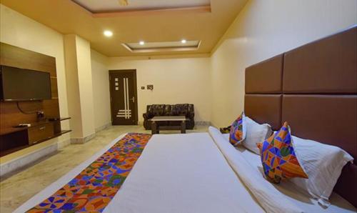 a bedroom with a large bed and a television at FabHotel RR Suites Guwahati in Guwahati