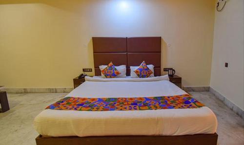 a bedroom with a large bed in a room at FabHotel RR Suites Guwahati in Guwahati
