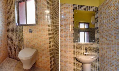 a bathroom with a toilet and a sink at FabHotel RR Suites Guwahati in Guwahati