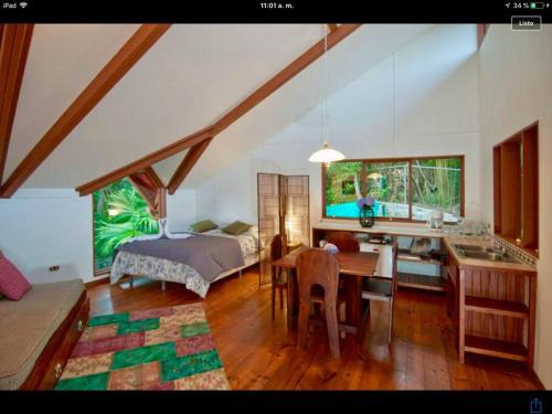 モンテベルデ・コスタリカにあるThe Cloud Forest Magical Villaのベッドルーム1室(ベッド1台付)、キッチン(テーブル付)