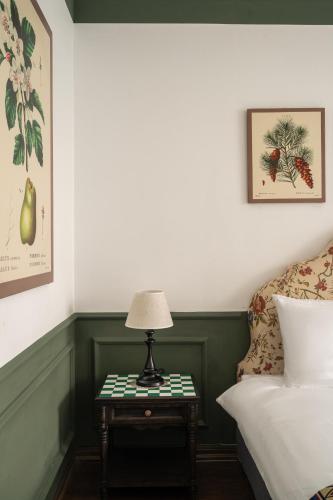 a bedroom with a bed and a table with a lamp at The Gate Boutique Hotel Sapa in Sa Pa