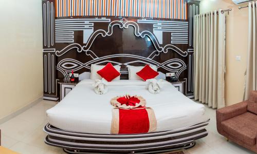 een slaapkamer met een groot wit bed met rode kussens bij Hotel Janmabhumi in Pashupatināth