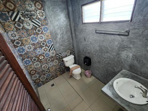 a bathroom with a toilet and a sink at Tiki Beach Koh Phangan in Ban Tai