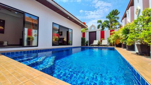 a swimming pool in the backyard of a house at Majestic Residence 2Bedroom PoolVilla51, Beach Gate in Pattaya South