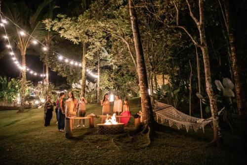 Un groupe de personnes debout dans un parc la nuit dans l'établissement Bali Palms, Tabanan, à Tabanan
