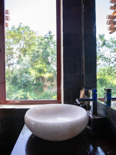 a white sink in a bathroom with a window at Pu Luong Jungle Lodge in Pu Luong