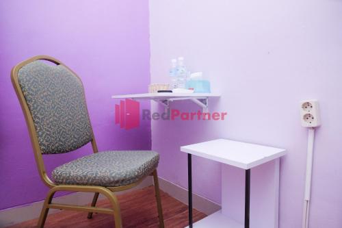 a chair and a table in a room at Janna Guest House Syariah Yogyakarta Mitra RedDoorz in Yogyakarta