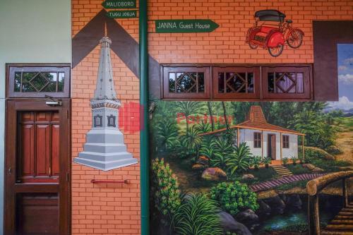 a mural on the side of a building with a church at Janna Guest House Syariah Yogyakarta Mitra RedDoorz in Yogyakarta
