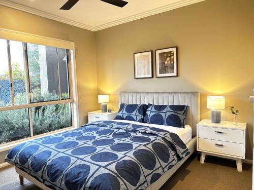 a bedroom with a bed and a large window at Luxury Holiday Home in Middle Ridge Toowoomba in Harristown