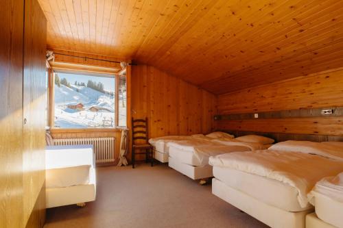 Habitación con 4 camas y ventana en Camp Suisse @ The Télécabine, en Les Crosets