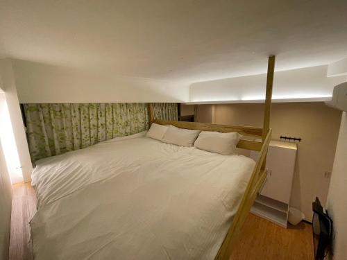 a large white bed in a small room at Dream Travel in Taipei