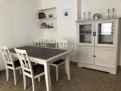 une cuisine avec une table, des chaises et une armoire dans l'établissement Appartement proche du PAL, à Dompierre-sur-Besbre