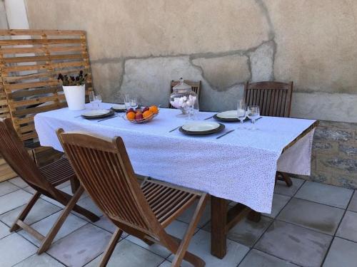 une table avec un chiffon de table blanc et un bol de fruits dans l'établissement Appartement proche du PAL, à Dompierre-sur-Besbre
