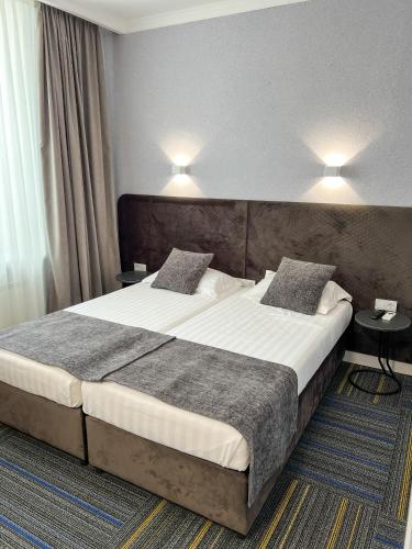 a hotel room with a large bed with two pillows at Жемчужина гостиница Балхаш in Balqash