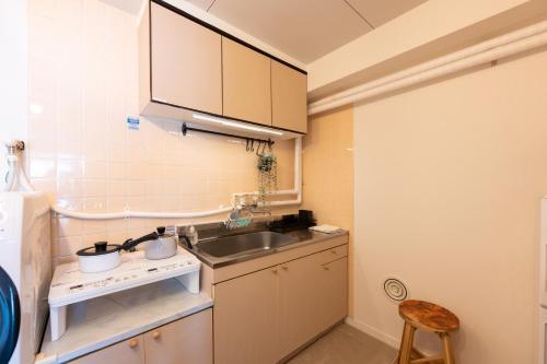 una pequeña cocina con fregadero y encimera en Beige, en Tokio