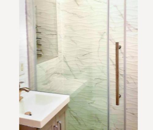 y baño con ducha y lavabo blanco. en 4 BR Luxury Apartment in Tribeca, en Nueva York