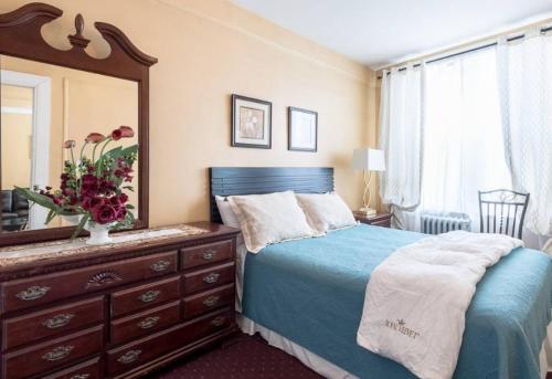 Schlafzimmer mit einem Bett, einer Kommode und einem Spiegel in der Unterkunft 4 BR Luxury Apartment in Tribeca in New York