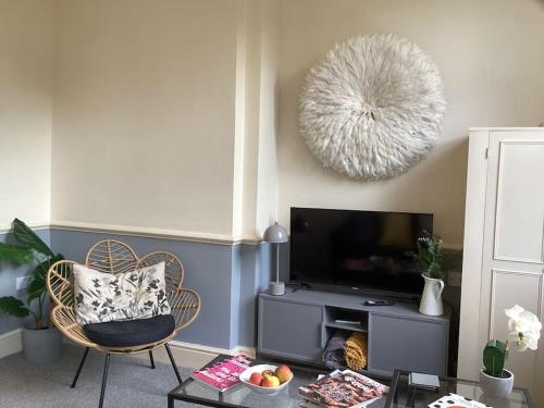 a living room with a tv and a chair at Fifty Shades of Gorgeous Greys in London