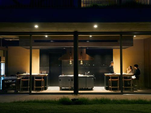 a group of people sitting at tables in a restaurant at night at YANMAR SUNSET MARINA CLUBHOUSE&HOTEL in Moriyama