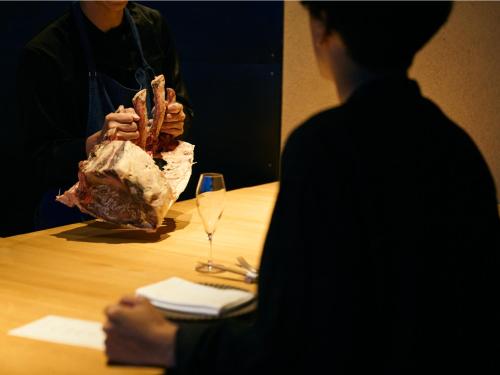 a woman sitting at a table with a glass of wine at YANMAR SUNSET MARINA CLUBHOUSE&HOTEL in Moriyama