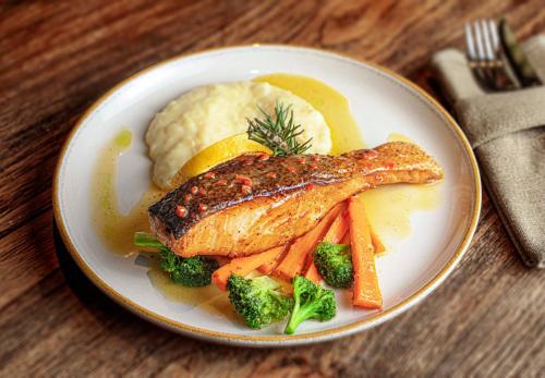 a plate of food with fish and vegetables and mashed potatoes at Gypsea Bali in Uluwatu