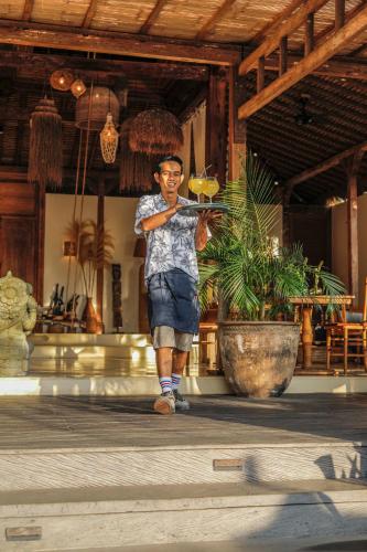 a man standing in front of a building holding a stick at Gypsea Bali in Uluwatu