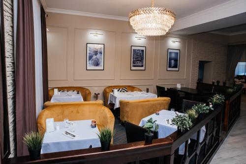 a restaurant with two tables and a chandelier at Жемчужина гостиница Балхаш in Balqash