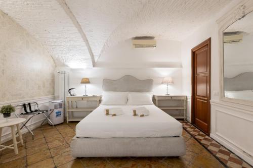 a bedroom with a white bed with two candles on it at Domus Suite 14 in Rome