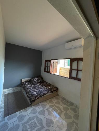 La maison des rives في Sada: غرفة نوم صغيرة بها سرير ونافذة