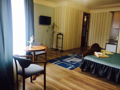 a bedroom with a bed and a table and a chair at Polyanskiy Zamok in Polyana