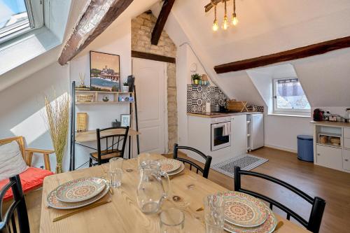 a kitchen and dining room with a table and chairs at "Le Beffroi" cocon en hyper centre de Nevers, service premium by PRIMO C0NCIERGERIE in Nevers