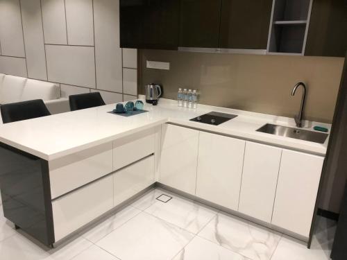 uma cozinha com armários brancos e um lavatório em WSD Times 8 Luxury Hotels & Residences em Kuala Lumpur
