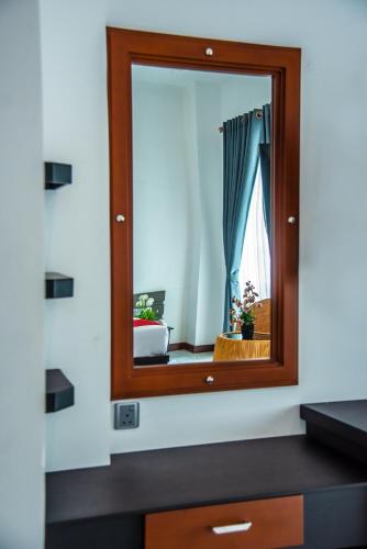 a mirror above a dresser in a room at The Pharo in Nittambuwa