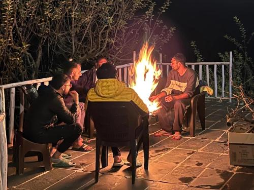 馬拉里的住宿－HimtrekStays Sethan, Heritage House, Manali，一群人围坐在火炉旁