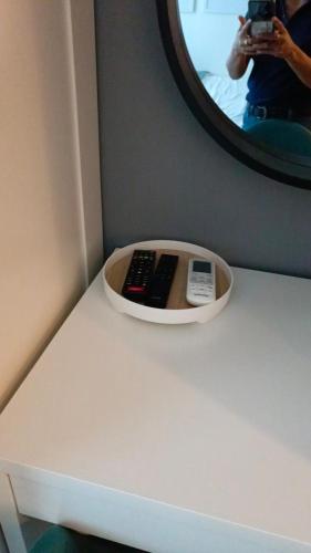 a person taking a picture of a counter with two remote controls at Cozy New 1BR Fame Residences Condo with Balcony in Manila