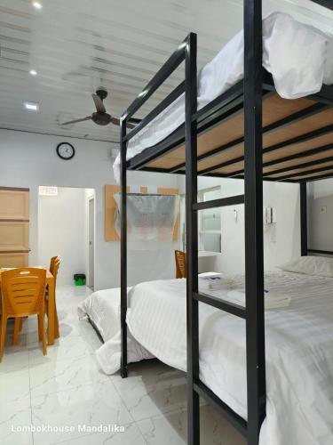 a bedroom with two bunk beds and a table at Lombokhouse Mandalika in Kuta Lombok