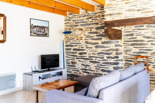 a living room with a stone wall at Maison de vacances 4 pers in Saint-Just